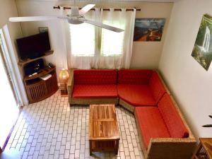 een woonkamer met een rode bank en een tafel bij Villa avec piscine privée, calme, proche des plages, à Sainte Anne in Sainte-Anne