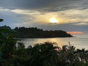 una vista de un cuerpo de agua con puesta de sol en Casita Corcovado, en Drake