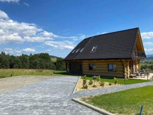 een groot houten huis met een gambrel dak bij SASÓWKA APARTAMENT in Maniowy