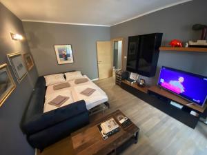 uma sala de estar com uma cama e uma televisão de ecrã plano em Apartment Toro em Split