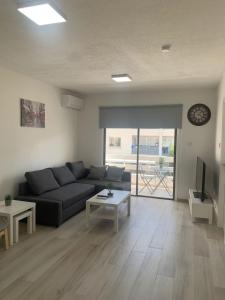 a living room with a couch and a table at Prestige Worldwide Apartments in Ayia Napa