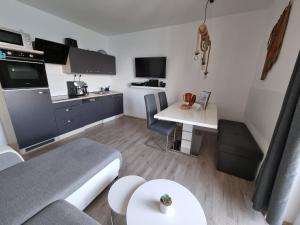 a small kitchen and living room with a couch and a table at Apartment Mara in Senj