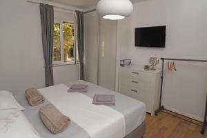 um quarto com duas camas e uma televisão na parede em Apartment Toro em Split