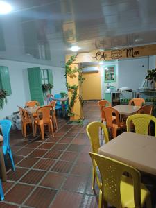 um restaurante com mesas e cadeiras num quarto em Hotel Costa mar em Barranquilla