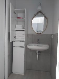 a bathroom with a sink and a mirror and towels at Alba House in Cuneo