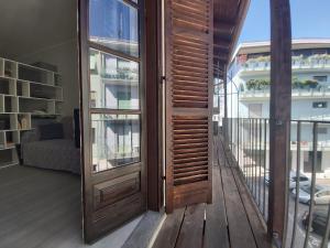 a wooden door in a room with a balcony at Alba House in Cuneo