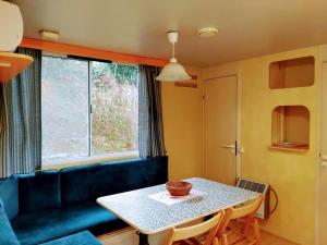sala de estar con mesa y sofá azul en Holiday Travel Genius at Toscana Holiday Village Camping, en San Romano