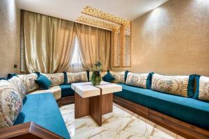 a living room with a blue couch and a window at Route de Miel in Agadir