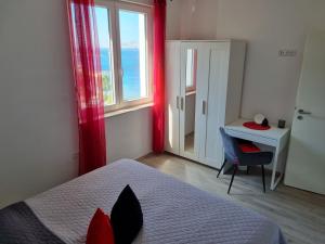 1 dormitorio con cama, escritorio y ventana en Apartment Mara, en Senj