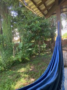 una hamaca azul en un patio con árboles en Casa dos Paulistas - Ilha de Boipeba, en Isla de Boipeba
