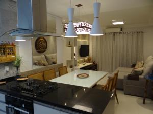 a kitchen and living room with a counter top at Piscina Aquecida-Wifi-Net-Condomínio Reserva da Mata Módulo 8 Riviera de São Lourenço in Riviera de São Lourenço