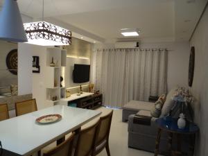 a kitchen and living room with a table and a couch at Piscina Aquecida-Wifi-Net-Condomínio Reserva da Mata Módulo 8 Riviera de São Lourenço in Riviera de São Lourenço