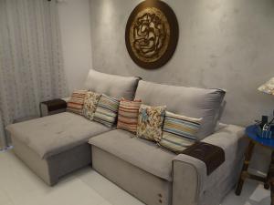 a couch with pillows on it in a living room at Piscina Aquecida-Wifi-Net-Condomínio Reserva da Mata Módulo 8 Riviera de São Lourenço in Riviera de São Lourenço