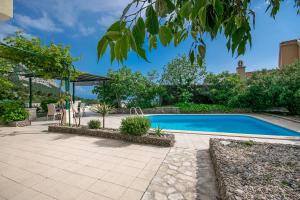 a swimming pool in a yard with a patio at Villa Marino in Makarska, private pool in Makarska