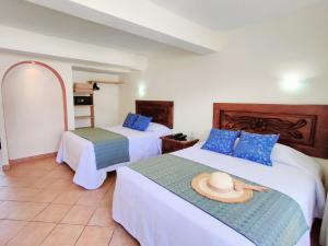 a hotel room with two beds with a hat on them at Hotel Rosita in Puerto Vallarta