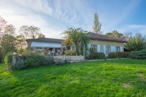 a house with a green yard in front of it at Le Paradis Saint Frajou, very beautiful Villa 200m2 swimming pool and style in Saint-Frajou