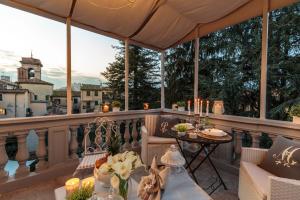 a balcony with chairs and a table with candles on it at CASA UCCELLINI with a Romantic Terrace in Lucca