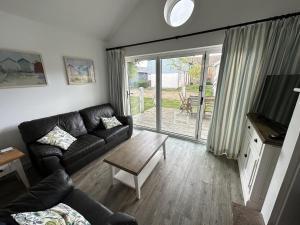 a living room with a couch and a table at Sea-Renity - Part of the The Bay Filey Holiday Village with pool, gym and direct beach access, pub, restaurant, tennis and meadows walks in Filey