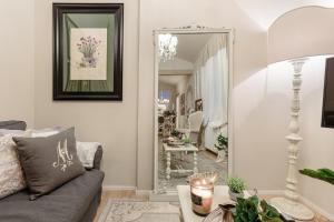 a living room with a couch and a mirror at CASA UCCELLINI with a Romantic Terrace in Lucca