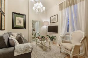 a living room with a couch and a tv at CASA UCCELLINI with a Romantic Terrace in Lucca
