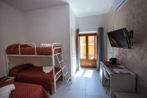 a small room with two bunk beds and a television at Nonno Giovanni in Gangi