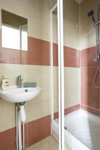 ein Bad mit einem Waschbecken und einer Dusche in der Unterkunft F1 Jean Jaurès 3G in Aubervilliers