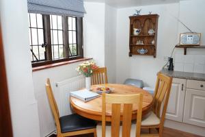 una pequeña cocina con mesa de madera y sillas en Character 2 double bedroom cottage in Shaftesbury, en Shaftesbury