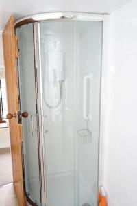 a shower with a glass door in a bathroom at Character 2 double bedroom cottage in Shaftesbury in Shaftesbury