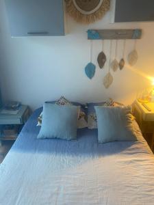 a bed with blue sheets and pillows in a bedroom at Vannina in Bastia