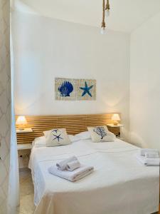 a bedroom with a large white bed with towels on it at le calette Marettimo in Marettimo