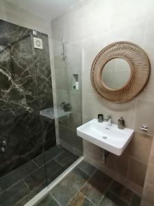 a bathroom with a sink and a shower with a mirror at Apartments Villa Kukoljac in Herceg-Novi
