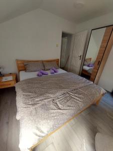 ein Schlafzimmer mit einem großen Bett mit lila Kissen darauf in der Unterkunft Apartman Trupsi in Jajce