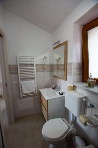 a bathroom with a toilet and a sink and a mirror at Nonno Giovanni in Gangi