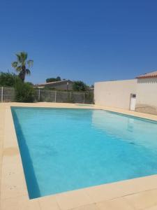une grande piscine d'eau bleue dans l'établissement Agréable Villa en petite Camargue 35 m2 WIFI, à Gallargues-le-Montueux