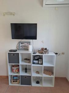une étagère blanche avec une télévision en haut dans l'établissement Agréable Villa en petite Camargue 35 m2 WIFI, à Gallargues-le-Montueux