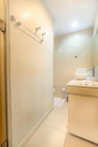 uma casa de banho com um chuveiro e um lavatório. em Sua Cobertura no Tabatinga Beach Resort com a Prosper em Nísia Floresta