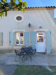 une table et des chaises devant un bâtiment dans l'établissement Agréable Villa en petite Camargue 35 m2 WIFI, à Gallargues-le-Montueux