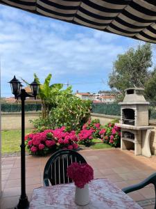 een tafel met een vaas met bloemen op een patio bij apartamento con jardín privado y barbacoa a 5 min playas santander in Santander