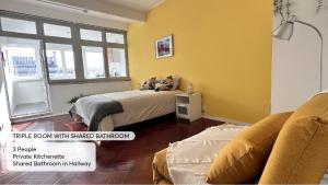 a bedroom with a bed in a room with yellow walls at Studio 59 Lisboa in Lisbon