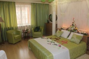 a bedroom with a large bed with flowers on it at Guesthouse Vizit in Chaykovskiy
