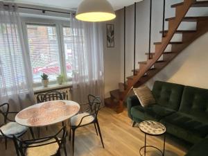 un soggiorno con divano verde e tavolo di Apartament Schodami do Nieba a Bytom