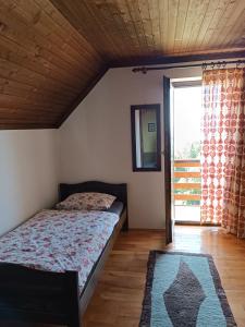 ein Schlafzimmer mit einem Bett und einem großen Fenster in der Unterkunft Kralj Matjaž - the green escape under Alps in Golnik