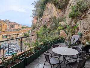 un patio con tavoli, sedie e una montagna di La Terrazza Di CavaLegni a Porto Santo Stefano