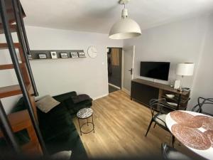 a living room with a couch and a television at Apartament Schodami do Nieba in Bytom