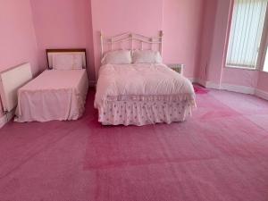 a pink bedroom with two beds and a pink carpet at Anfield view in Liverpool