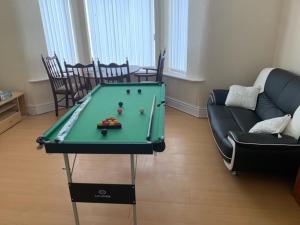 a living room with a pool table and a couch at Anfield view in Liverpool