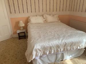 a bedroom with a large white bed and a lamp at Anfield view in Liverpool +2 photos