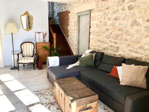 ein Wohnzimmer mit einer Couch und einer Steinwand in der Unterkunft Charmant cottage à la campagne in Marval + 1 Foto