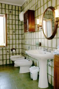 bagno con lavandino, servizi igienici e specchio di Villa Ines a Teulada