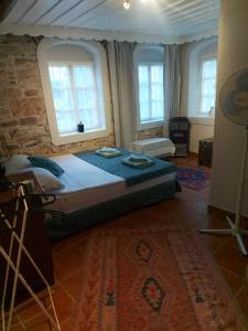 ein Schlafzimmer mit einem Bett in einem Zimmer mit Fenstern in der Unterkunft Mimosa House Ayvalık in Ayvalık